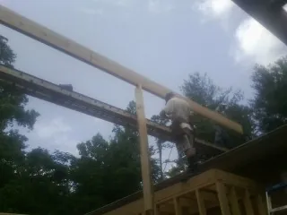 Carpenter setting a ridge beam over a new addition frame — Ice Dam Removal by Roofing Brothers in Ventura
