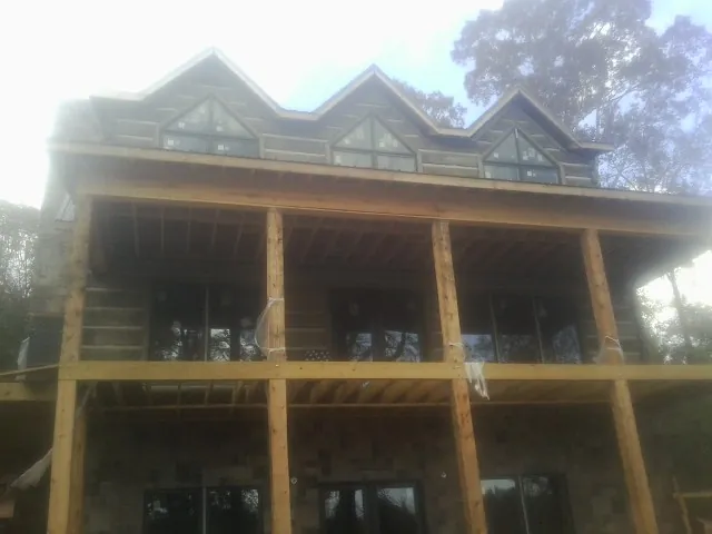 Dormers and porch framing on a large log home under construction — Roof Coating work by our crew in Ventura